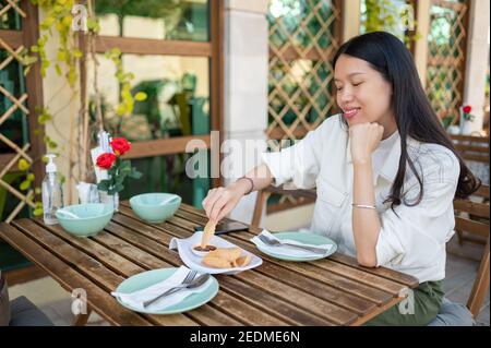 Asiatische Frau mit thai Garnelen Cracker Vorspeise vor dem Essen in Das Thai Food Restaurant Stockfoto