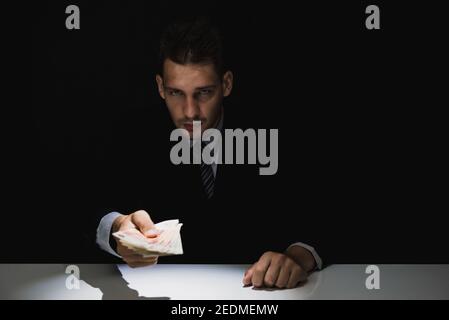 Tricky schlaue Geschäftsmann Geld im Dunkeln, Bestechung und Korruption Konzepte geben Stockfoto