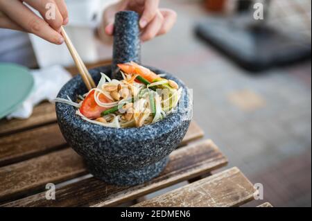 Frau mit grünen Papaya-Salat namens som tum in einem Thailändisches Essen Restaurant in der Nähe Stockfoto