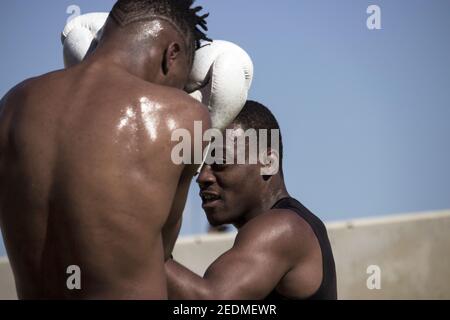 Schwarze Profi-Boxer Trainer Black Boxing Anfänger in einer Outdoor-Boxen-Klasse aufgrund der Schließung von Turnhallen. Boxen Schwitzen und Training 2021 Stockfoto