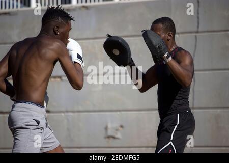 Schwarz Profi-Boxer Trainer ein weiterer Black Boxing Anfänger in einer Boxklasse Schwitzen im Outdoor, Boxen und Training Konzept 2021. Stockfoto