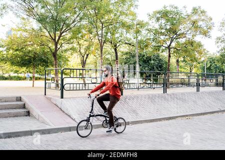 Stock Foto von bärtigen Mann auf seinem abnehmbaren Fahrrad auf der Straße. Stockfoto