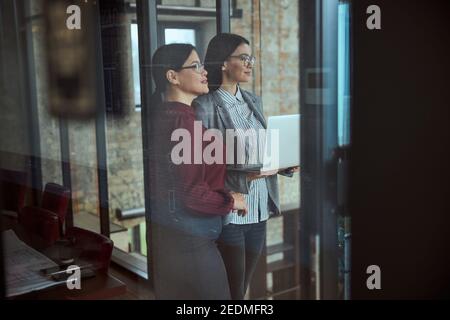 Attraktive internationale weibliche Blick durch Glaswand Stockfoto