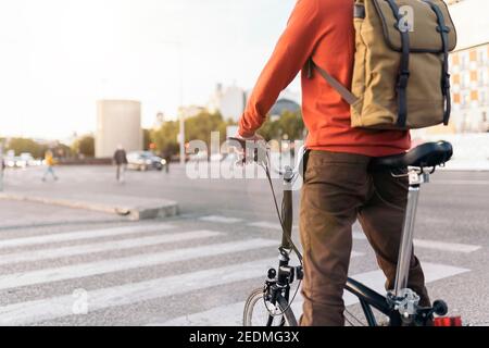 Stock Foto von gesichtslosen Mann, der ein Fahrrad auf der Straße wartet. Stockfoto