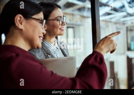 Fröhliche internationale weibliche Person mit angenehmen Gespräch Stockfoto