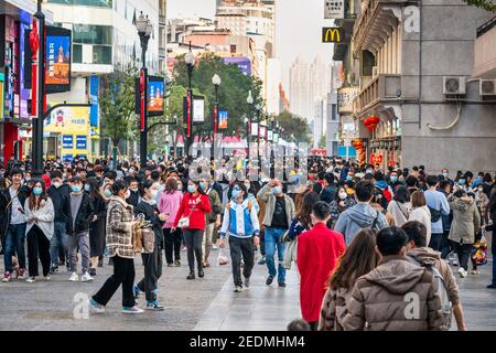 Wuhan China , 14. Februar 2021 : Menschenmenge mit chirurgischen Gesichtsmaske auf der chinesischen Neujahrswoche 2021 Urlaub in Jianghan Fußgängerzone in Stockfoto