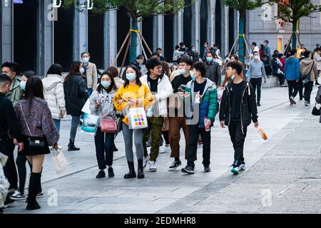 Wuhan China , 14. Februar 2021 : Gruppe von Menschen tragen chirurgische Gesichtsmaske auf der chinesischen Neujahrswoche 2021 Urlaub in Jianghan Fußgängerzone in Stockfoto