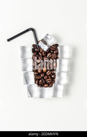 Tasse Eiskaffee mit Eiswürfeln und Kaffeebohnen. Kreatives Sommer-Minimal-Konzept. Stockfoto