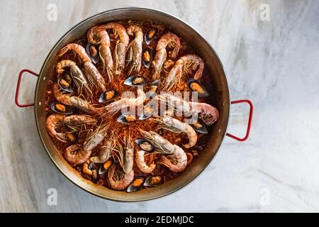 Blick von oben auf typische spanische Paella mit Meeresfrüchten in traditioneller Pfanne Stockfoto