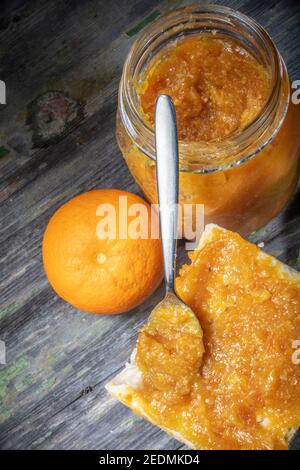 Pure Fresh Domestic Orange Marmelade auf Brotaufstrich mit Löffel in senkrechter Position schräg. Speicherplatz Kopieren Stockfoto
