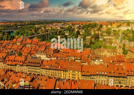 Dramatischer Sonnenuntergang Himmel mit Wolken der Berner Altstadt in der Schweiz, UNESCO-Weltkulturerbe vom Dom Glockenturm. Luftaufnahme der Skyline Stockfoto