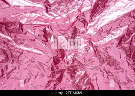 Abstrakt rosa zerknitterte Folie Hintergrund. Minimales Partykonzept. Stockfoto