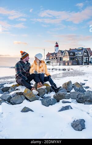 Paar Männer und Frauen am Leuchtturm von Urk Niederlande im Winter im Schnee. Winterwetter in den Niederlanden von Urk Stockfoto