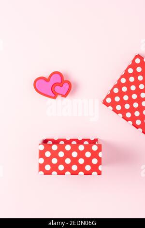 Geschenkbox mit Herzen auf rosa Hintergrund. Minimales Liebeskonzept. Stockfoto