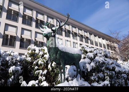 31,01.2021, Bremen, Bremen, Deutschland - verschneite Bronzeskulptur eines Hirsches und Rhododendron-Busches vor dem Parkhotel, der wichtigsten Adresse der Stadt Stockfoto