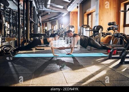 Glückliches, athletisches Paar, das zusammen Core Workout macht Stockfoto