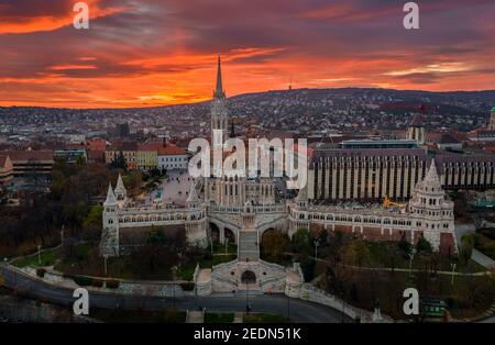 Budapest, Ungarn - Luftaufnahme eines dramatischen goldenen Sonnenuntergangs hinter der berühmten Fischerbastei (Halaszbastya) und der Matthias-Kirche im Winter danach Stockfoto