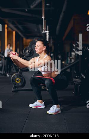 Fröhliche Frau tun Unterkörper-Training drinnen Stockfoto