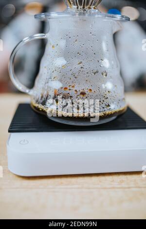 Glaskanne mit heißem Kaffee - tropft durch den Filter Und gemahlene Bohnen Stockfoto