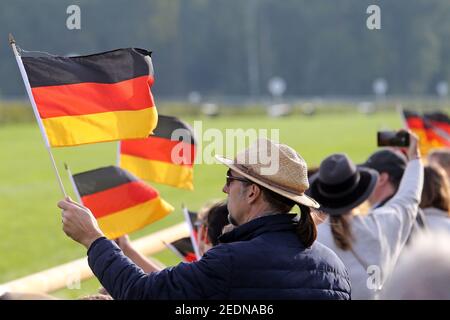 03,10.2020, Hoppegarten, Brandenburg, Deutschland - Mann hält die Nationalflagge am Tag der Deutschen Einheit. 00S201003D474CAROEX.JPG [MODELLVERSION: NEIN, PRO Stockfoto