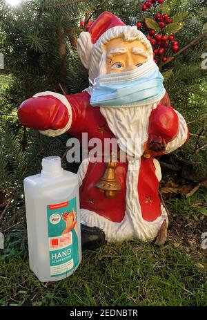05,12.2020, Berlin, Berlin, Deutschland - Weihnachtsmann-Figur mit Mund-Nase-Schutz, daneben eine Flasche mit Händedesinfektionsmittel. 00S201205D Stockfoto