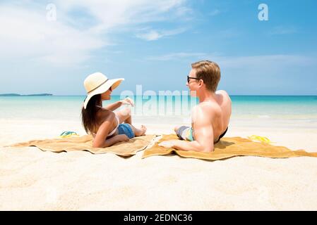 Pärchen liegen am weißen Sandstrand und entspannen sich und sonnen sich im Sommer auf der Insel Koh samui, Thailand Stockfoto