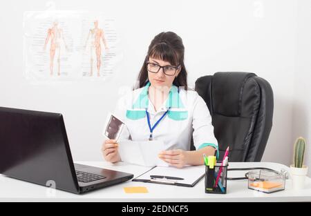 Junge schöne Mädchen Arzt schaut auf die Testergebnisse des Patienten. Arztpraxis in der Klinik, Endoskopist Stockfoto