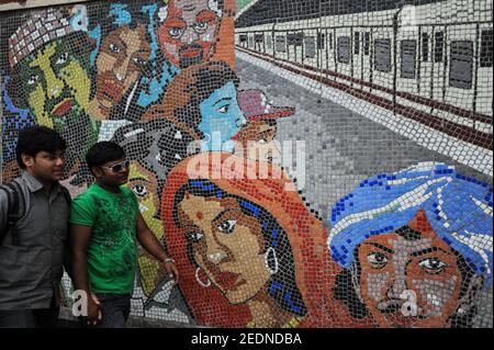 21,02.2011, Kalkutta, Westbengalen, Indien - zwei junge Männer gehen an einem bunten Kachelmosaik vor einer U-Bahnstation vorbei. 0SL110221D009CAROEX.JP Stockfoto