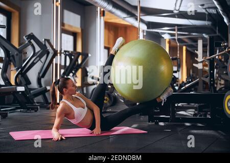 Fröhliche junge Frau tut abs-Workout mit Outfit Stockfoto