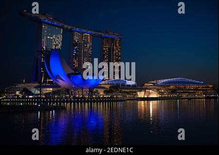 02,12.2020, Singapore, , Singapore - Blick über Marina Bay auf das beleuchtete Luxushotel Marina Bay Sands und das ArtScience Museum während der Weltw Stockfoto