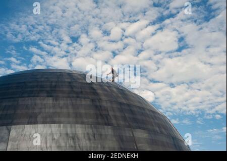 05,01.2021, Singapur, Singapur - EIN Arbeiter führt Wartungsarbeiten an der gewölbten Glasfassade façade des neuen Apple Flagship Stores in Marina Bay Sands durch. Stockfoto