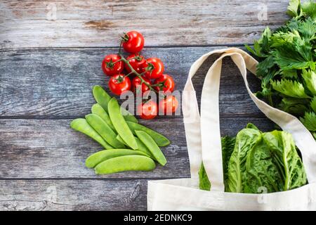 Öko Einkaufstasche mit frischem Bio-Gemüse und Salat auf Holzhintergrund, Draufsicht, Flat Lay Stockfoto