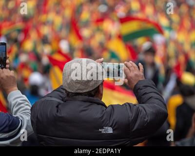 Zwei Männer fotografieren Massen von Demonstranten nach dem Rücktritt von Präsident Evo Morales in La Paz, Bolivien, 10. November 2019. Stockfoto