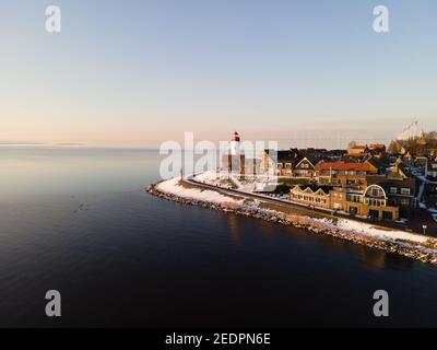 Schneebedeckter Strand während wnter von Urk Leuchtturm in den Niederlanden. Kaltes Winterwetter in den Niederlanden Stockfoto