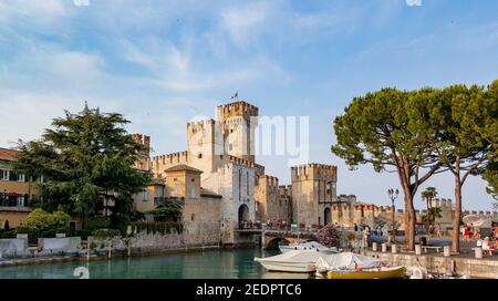 SIRMI, ITALIEN - 12. Feb 2021: Touristen besuchen ein Märchenschloss in Sirmione, Italien. Festung aus dem 13th. Jahrhundert, Rocca scaligera. Stockfoto