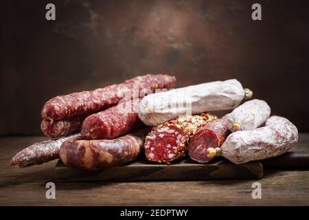Verschiedene Arten der Salami und der Würste auf hölzern Platine Stockfoto