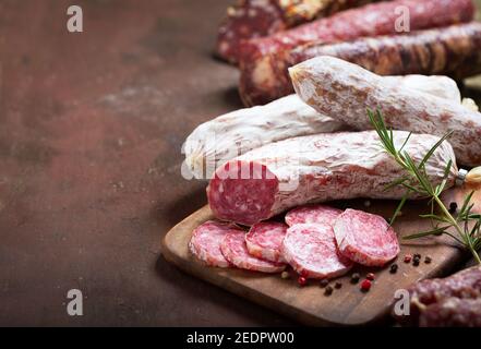 Verschiedene Arten von Salami, Schinken und Würstchen auf einem Holzbrett Stockfoto