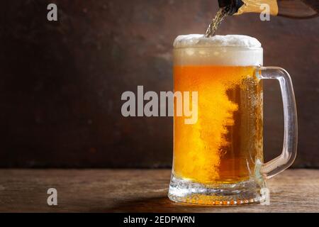 Kaltes Bier aus der Flasche in den Becher Stockfoto