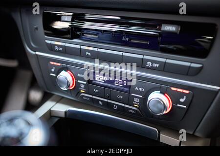 Modernes Klimabedienfeld für Fahrer und Beifahrer mit geringer Schärfentiefe. Klimazonen-Regelung. Detail der Fahrzeuginnenausstattung. Multimedia-Radio-cd Stockfoto