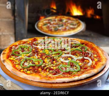 Pizza mit Mais, Speck, Paprika, Zwiebeln, Erbsen Stockfoto