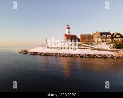 Schneebedeckter Strand während wnter von Urk Leuchtturm in den Niederlanden. Kaltes Winterwetter in den Niederlanden Stockfoto