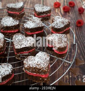 Herzförmige Brownie-Kekse mit frischer Himbeercreme. Stockfoto