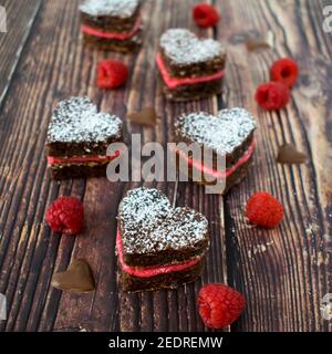 Herzförmige Brownie-Kekse mit frischer Himbeercreme. Stockfoto