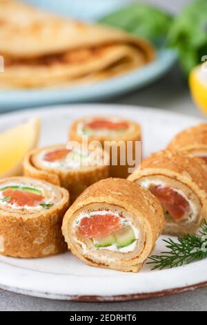 Crepe Lachsbrötchen mit Frischkäse und Gurke. Party Vorspeise Essen Stockfoto