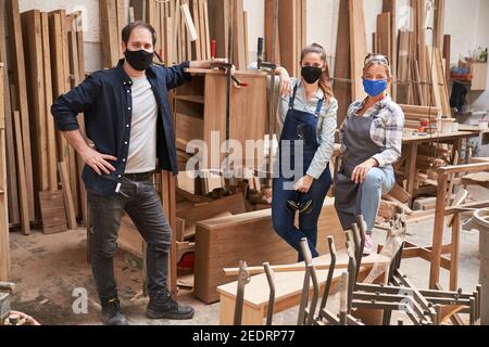 Gruppe von Handwerkern, Auszubildenden und Ausbildern mit Gesichtsmasken wegen Covid-19 Stockfoto