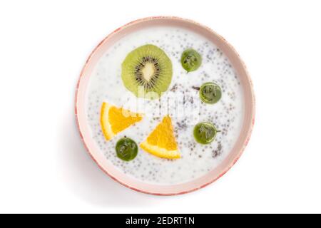 Joghurt mit Kiwi, Stachelbeere, Chia in Keramikschale isoliert auf weißem Hintergrund. Draufsicht, Nahaufnahme. Stockfoto