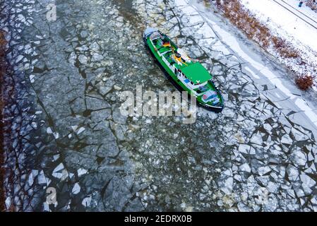 Domitz, Deutschland. Februar 2021, 15th. 15. Februar 2021, Mecklenburg-Vorpommern, Dömitz: Der Eisbrecher Wisent bricht die Eisdecke im Anflug auf den Hafen von Dömitz an der Elbe auf. (Luftaufnahme mit Drohne) das eisige Wetter der letzten Tage hat dazu geführt, dass sich Eis auf Flüssen, Seen und Kanälen bildet. Foto: Jens Büttner/dpa-Zentralbild/dpa Quelle: dpa picture Alliance/Alamy Live News Stockfoto