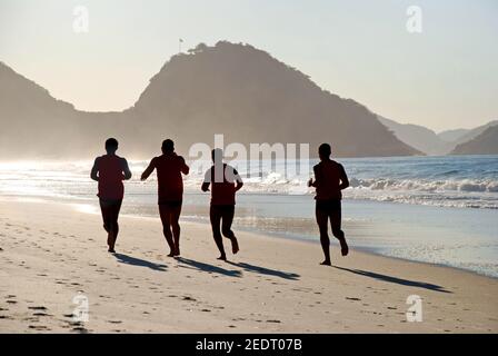 Mann laufen am Strand der Copacabana Stockfoto