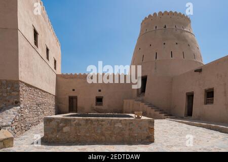 Innenhof einer kleinen mittelalterlichen arabischen Festung in Bukha, Oman. Fenster, Türen und Rundturm. Stockfoto