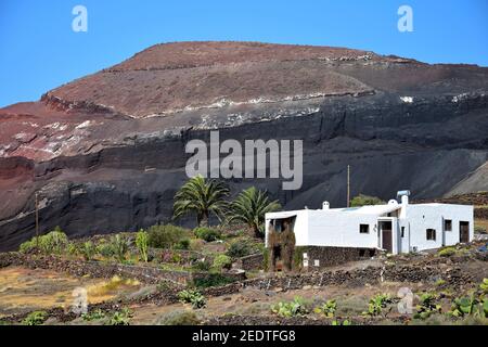 Wunderschöne Vulkanlandschaft mit einem weißen Haus davor. Lanzarote, Kanarische Inseln, Spanien. Caldera de Masion in der Nähe von Femés. Bild aus öffentlicher Gruu Stockfoto